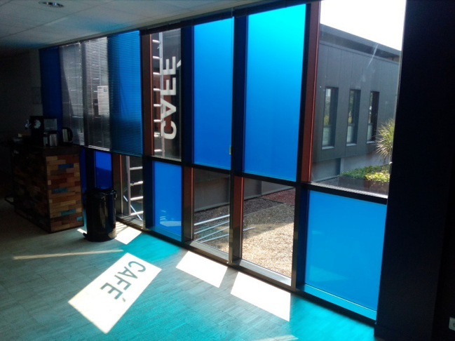 Vitrophanie bleue avec lettrage découpé Café sur les baies vitrées d'un espace de bureau