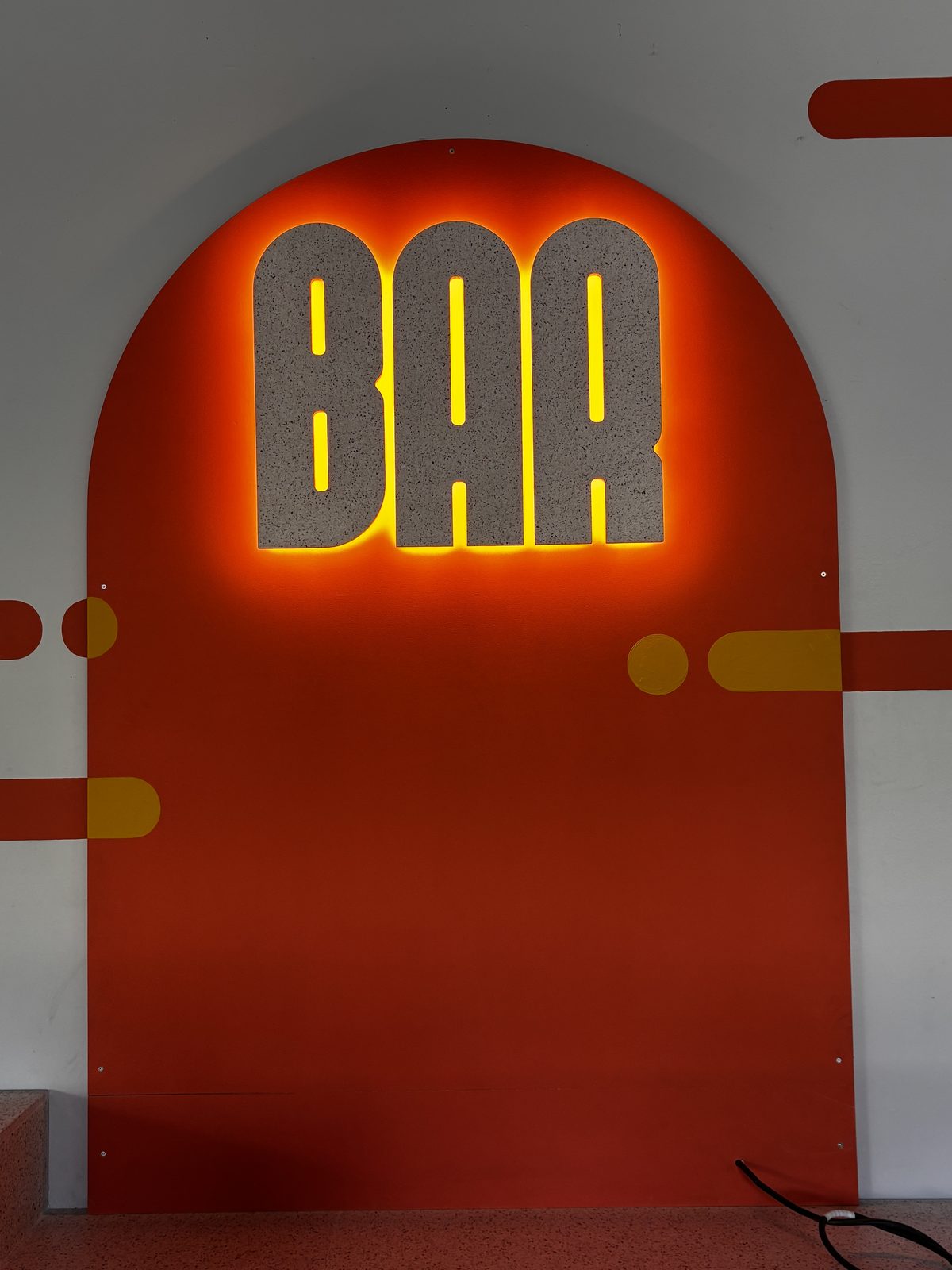 Enseigne lumineuse BAR en matériau coquillages recyclés sur arche orange, signalétique intérieure du Laps à Nantes