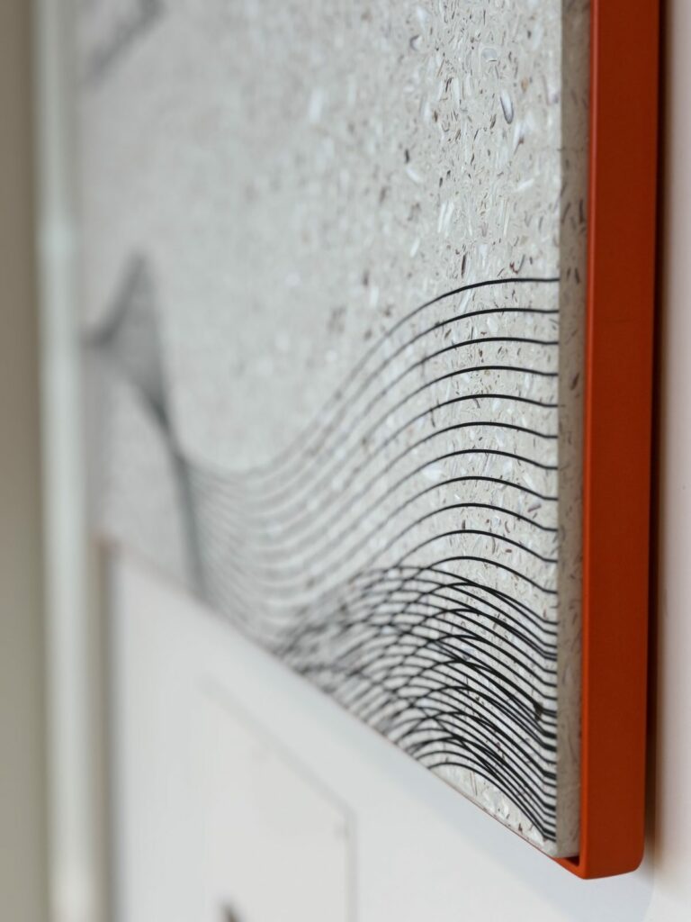 Détail d'une plaque de signalétique en matériau recyclé à chant laqué orange, Maison des Skippers à Lorient